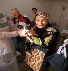 An elderly Romanian lady very happy after her pet is sterilised