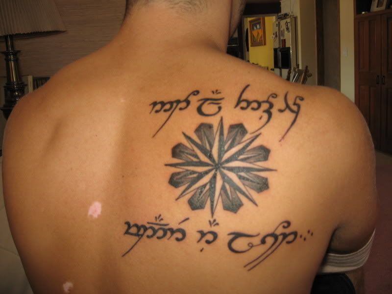 upper back, This Too Shall Pass running along her left shoulder blade,