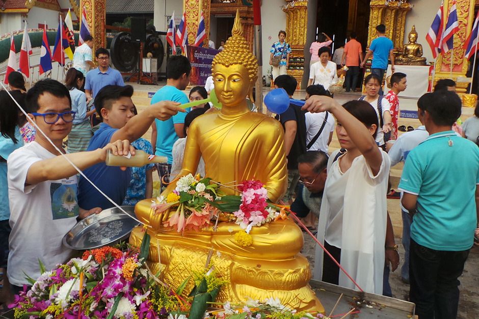 Umat Buddha menyiramkan air ke rupaka Buddha di Vihara Suan Tan, Provinsi Nan