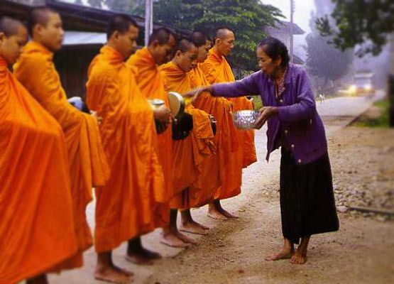 Seorang umat mempersembahkan makanan kepada para bhikkhu.